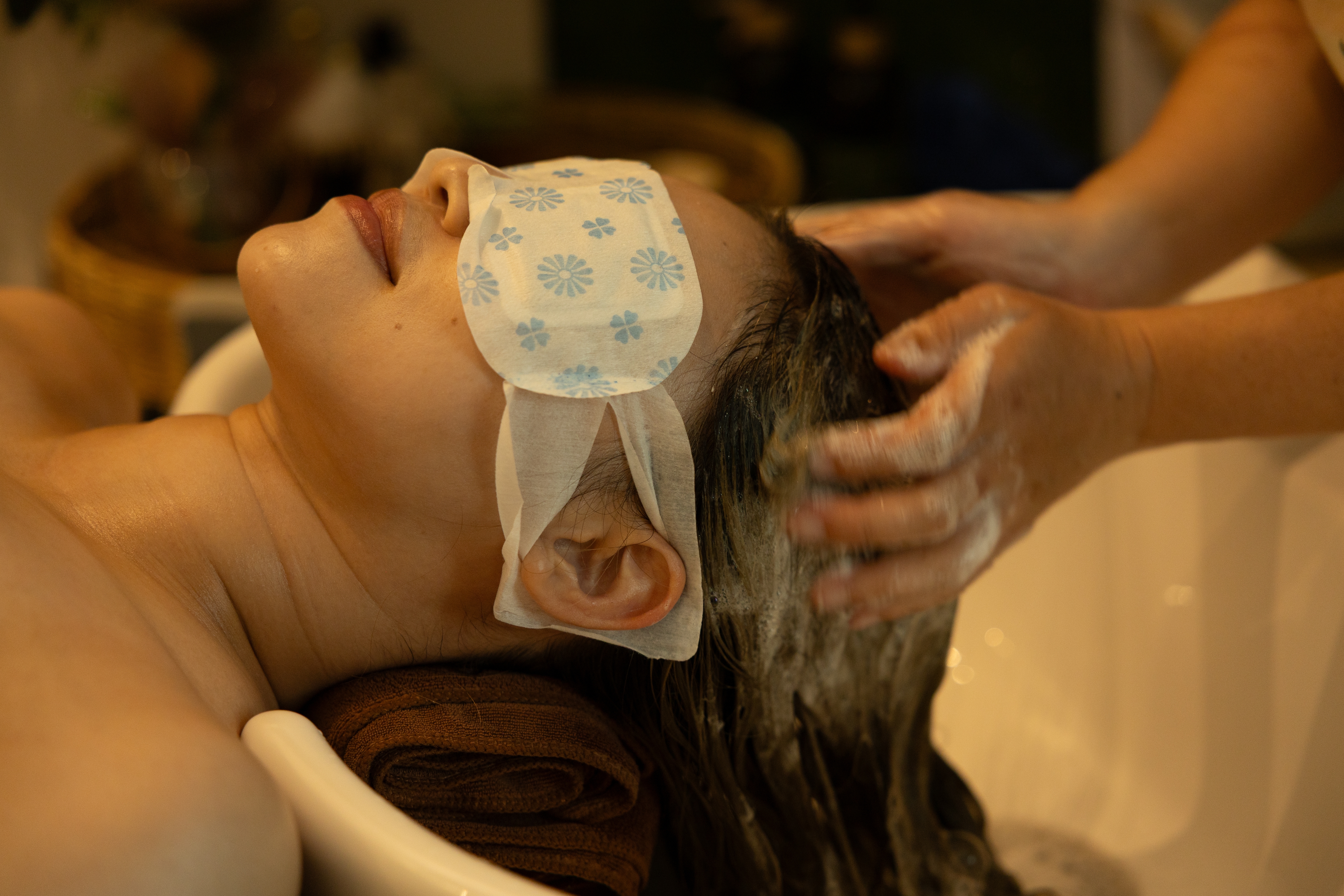 Vrouw ligt ontspannen, terwijl ze een Harmony Tide Ritual japanese head spa massage krijgt